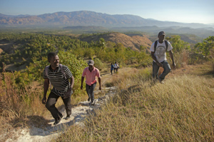 Hillside with trees and two volunteers in Haiti